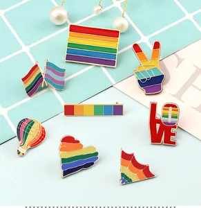Vibrant collection of rainbow enamel pins with heart, flag, and peace sign motifs