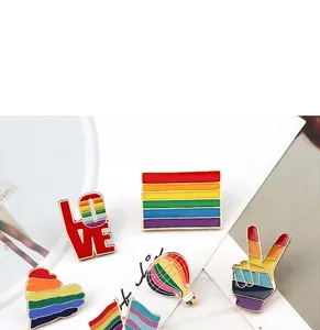 Detailed view showing various rainbow striped enamel pin badges for backpack decoration.