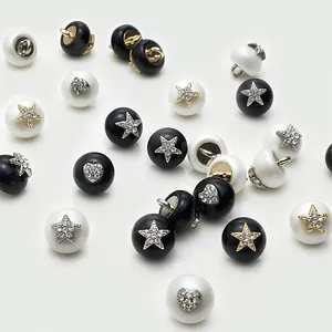 Dettaglio elegante di bottoni di perle sintetiche con stelle e cuori in strass per vestiti