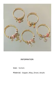 Gros plan de bracelets à breloques dorés avec zircons roses et pendentifs élégants.