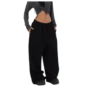 Detail view of black baggy street style sweatpants with a loose straight-leg fit.