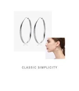 Grandes créoles en argent sterling 999 avec finition polie sur un mannequin féminin