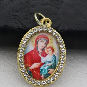 Detailed view of oval rhinestone pendant featuring a religious Virgin Mary icon