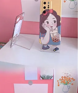 Close-up detail of transparent acrylic phone stand with cute rabbit and astronaut prints