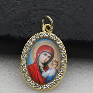 Close-up of oval micro-pave religious pendant with Virgin Mary icon and rhinestones