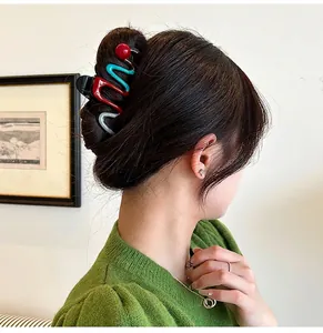 Stylish wavy shark hair clip with red and turquoise color contrast shown on model