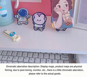 Close-up of cute rabbit and astronaut acrylic mobile phone stands on a white desk.