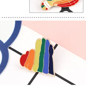 Macro detail of colorful striped heart enamel pin showing smooth oil-dripping texture