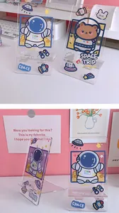 Transparent acrylic phone stand with cute cartoon astronaut and space trip motifs