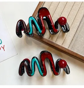 Glossy zigzag hair claw clips with colorful accents on jewelry tray