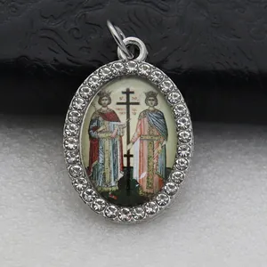 Macro view of an oval pendant featuring a rhinestone border and religious art insert detail.
