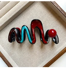 Large wavy shark hair claw clip with red and blue color contrast and round bead detail