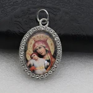 Close-up of oval micro-pave religious icon pendant with rhinestones and Mary motif