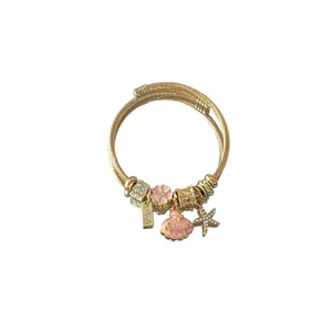 Vue détaillée d'un bracelet doré avec des breloques en coquillage et étoile de mer