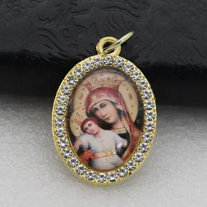 Detailed macro shot of an oval gold-plated pendant with religious icon and rhinestones