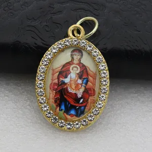 Detailed view of oval pendant featuring Madonna and Child icon with rhinestone border.