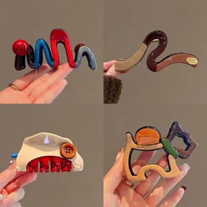 Set of large artistic hair claw clips in vibrant colors and abstract wave shapes