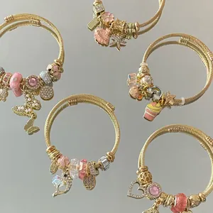 Bracelets ajustables en acier doré avec breloques en cristal rose et divers pendentifs