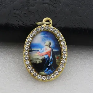 Close-up view of a religious oval pendant with Jesus illustration and rhinestones