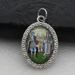 Detail of an oval micro-paved rhinestone pendant with a religious angel illustration