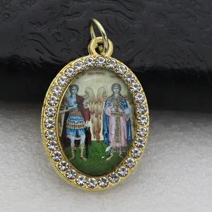 Detailed macro view of an oval gold pendant with micro-pave stones and religious icon