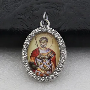 Detail shot of an oval pendant with micro-pave stones and vintage saint portrait