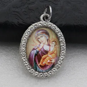 Close-up detail of oval religious icon pendant with sparkling rhinestone border
