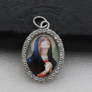 Close-up of oval religious pendant with micro-paved rhinestones and Virgin Mary portrait