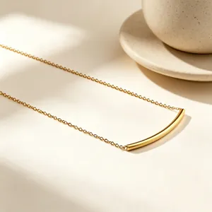 Detailaufnahme einer minimalistischen, goldfarbenen Halskette aus Edelstahl mit Bogen