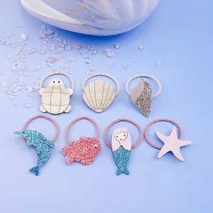 Detail of cute glitter ocean themed hair ties with mermaid and seashell shapes.