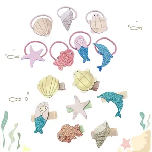 Detail of ocean-themed children's hair clips and ties with glitter and PU leather.
