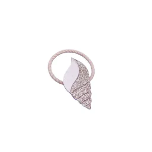 Macro view of a cute glitter seashell hair tie for kids made with soft PU leather