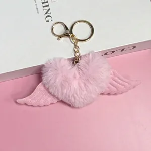 Vista dettagliata di un portachiavi a cuore in peluche rosa con ali in tessuto coordinate