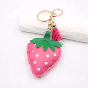Pink strawberry PU leather keychain with tassel and gold metal ring for bag charm.