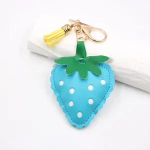 Blue faux leather strawberry keychain pendant with white polka dots and yellow tassel