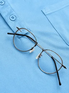Nahaufnahme von hellblauem, atmungsaktivem Mesh-Poloshirt mit Metallrahmen-Brille