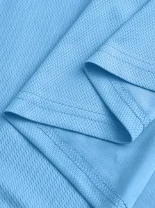 Nahaufnahme des hellblauen, atmungsaktiven Mesh-Stoffs eines Sport-Poloshirts mit Naht