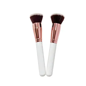 Detail view of professional makeup brushes featuring white handles and rose gold ferrules.