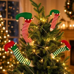 Detailed view of colorful striped Christmas elf leg ornaments in a glowing tree