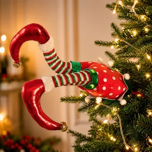 Whimsical red elf legs decoration stuck in a Christmas tree with festive lights.