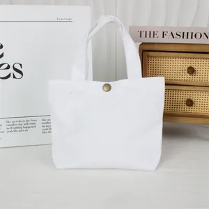 Minimalist solid white canvas tote bag featuring a vintage bronze snap button detail