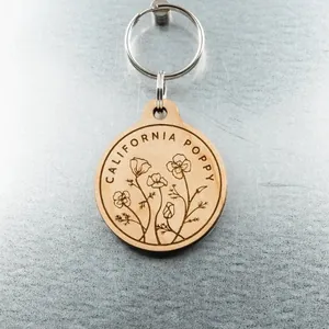 Engraved walnut wood circular keychain featuring California poppy floral design.