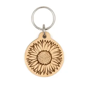 Close-up macro view of a detailed laser-engraved sunflower on a round wooden keychain
