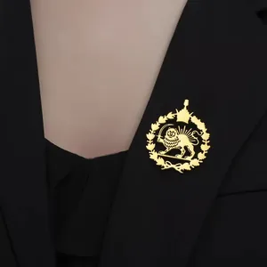 Detailed view of a golden stainless steel lion and sun wreath brooch on a black suit blazer