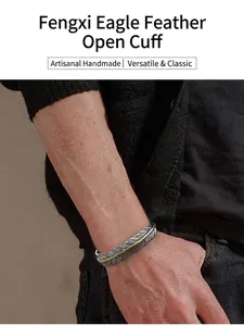 Detailansicht eines silbernen Vintage-Feder-Armreifs am Handgelenk eines Mannes.