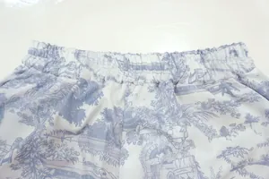 Detailed close-up view of elastic waistband on blue toile de jouy print wide-leg pants