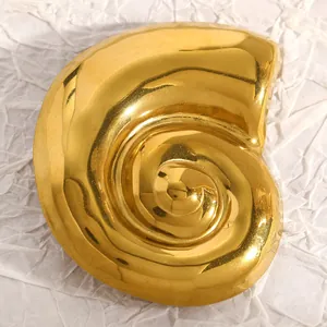 Vue détaillée d'une broche en forme de coquillage doré en acier inoxydable poli