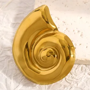 Vue macro de haute qualité d'une broche en acier inoxydable doré en forme de coquillage