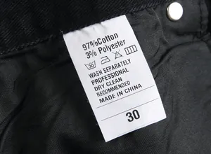 Close-up of material label on black men's jeans showing cotton and polyester blend.