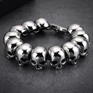Punk style men's titanium steel bracelet featuring detailed silver skull head charms